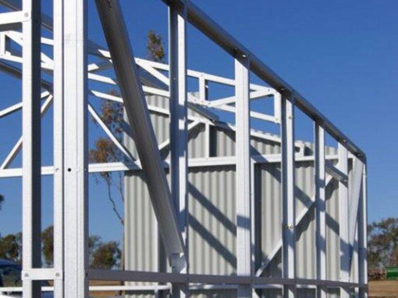 Photo of stud framing in a building with some cladding added to one of the walls.