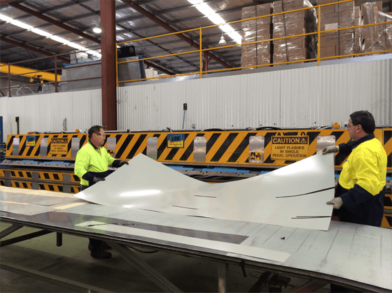 Photo of machine operators making a custom flashing.