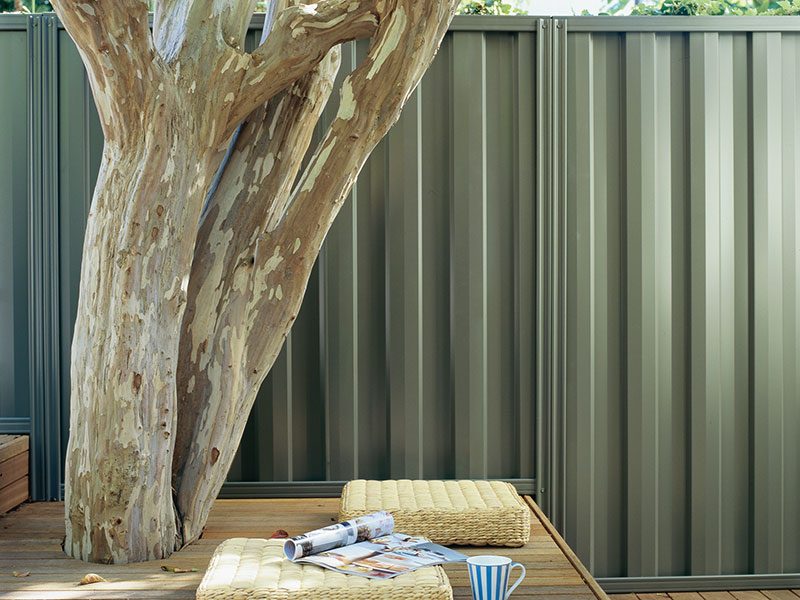 Metline Premium Colorbond fence with tree and cushion.